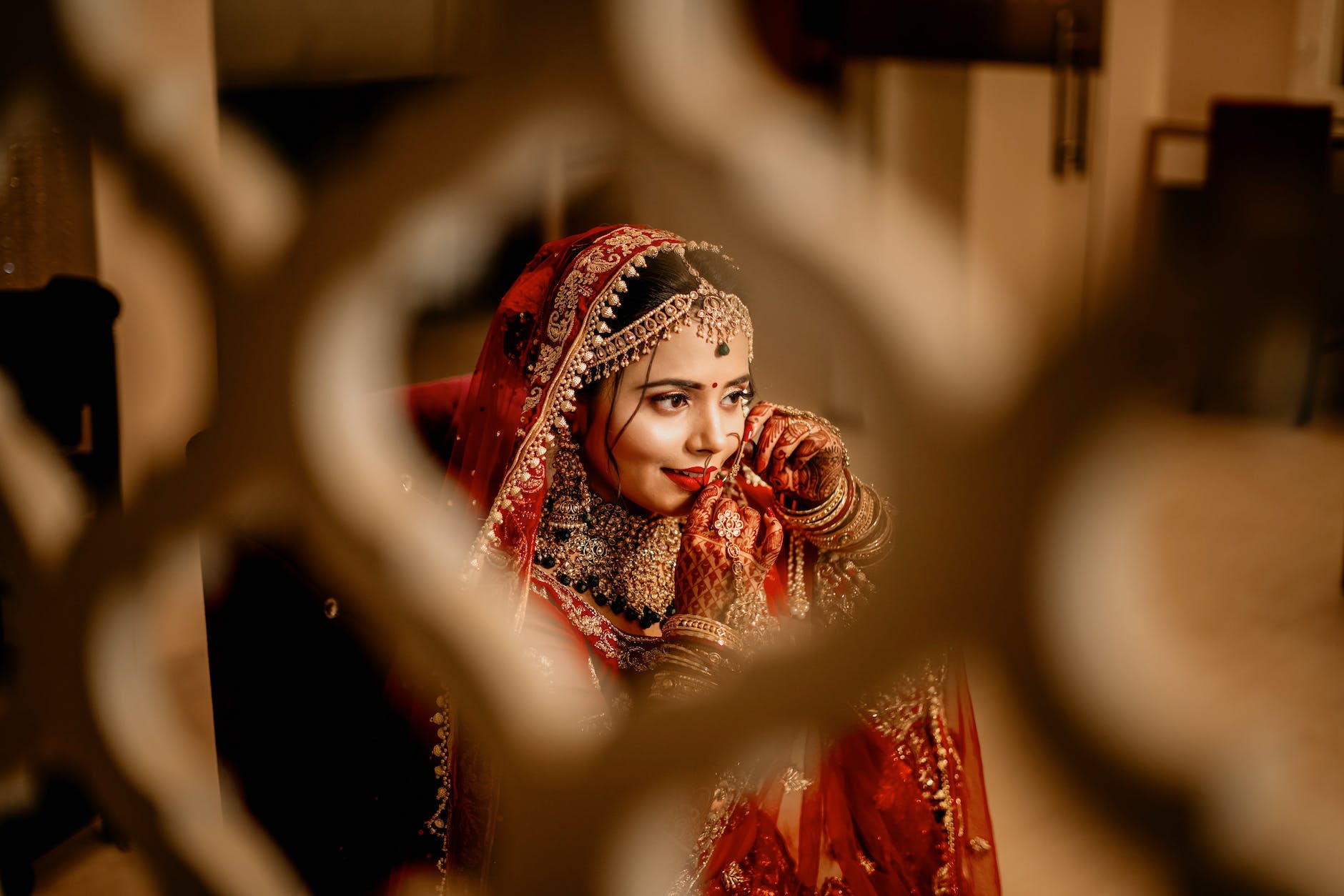 Indian bride in traditional attire, preparing for her wedding with intricate jewelry and a beautifully adorned outfit, radiating elegance and joy.